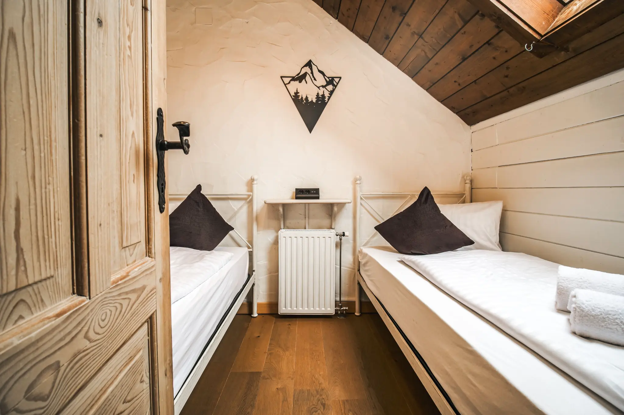 Schlafzimmer 2 MountainView Lodge Sankt Oswald — 2 Einzelbetten mit alpiner Bergdeko